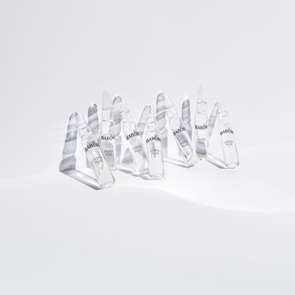 Mehrere Babor Hydra Plus Ampullen auf einer weißen Oberfläche. Die Ampullen werfen Schatten.