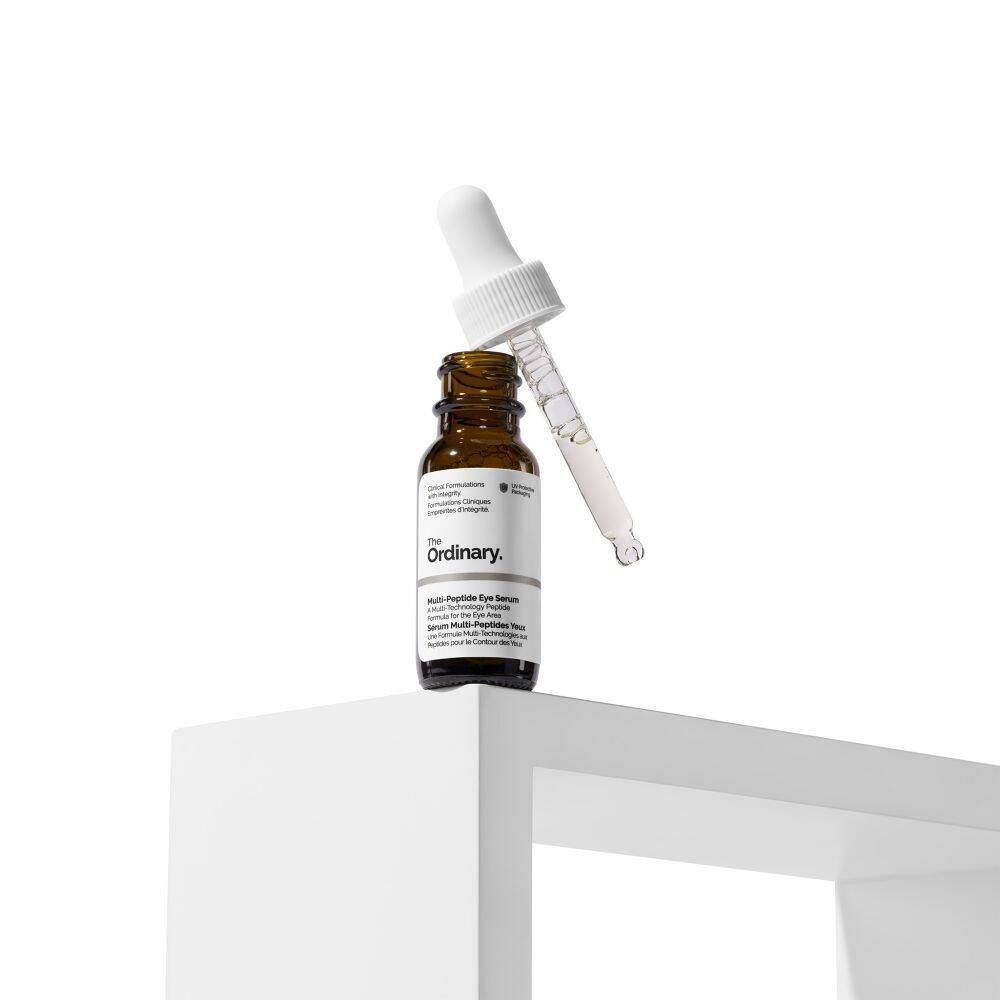 Eine Flasche The Ordinary Multi-Peptide Eye Serum mit Pipette, auf einem weißen Podest.