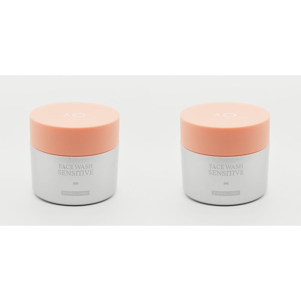 Twee potten met oranje deksels. Tekst "FACE WASH SENSITIVE" is zichtbaar.