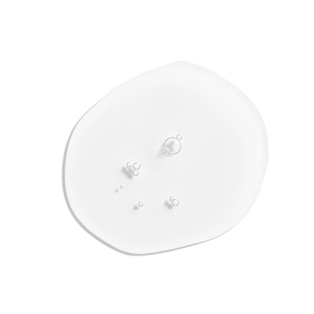 Klare Flüssigkeit mit Bläschen auf weißem Hintergrund.