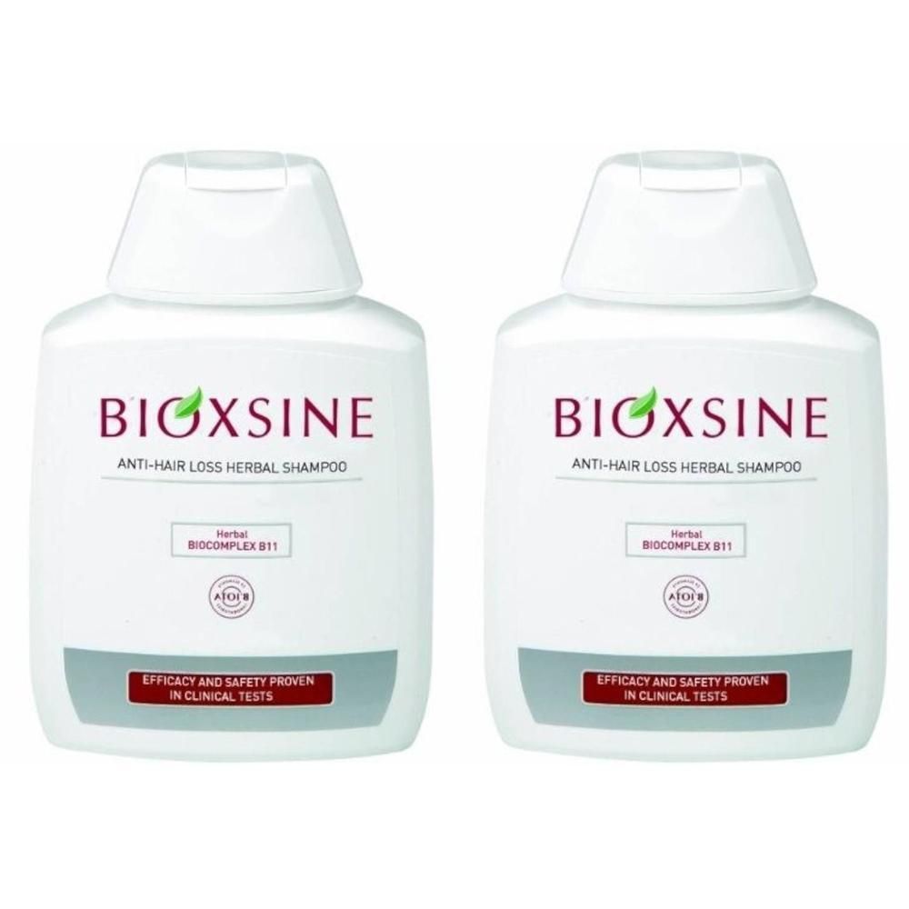 Zwei weiße Shampoo-Flaschen mit roter und grüner Beschriftung. Aufschrift: BIOXSINE Anti-Haarausfall Herbal Shampoo.