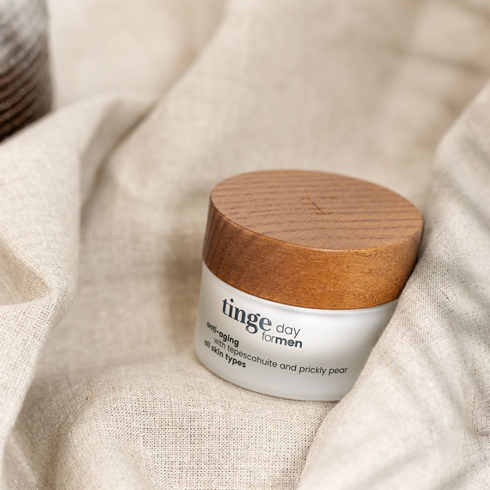 Tiegel mit Holzdeckel auf Stoff. Aufschrift: Tinge day for men, anti-aging, mit Tepescohuite und Kaktusfeige, alle Hauttypen.