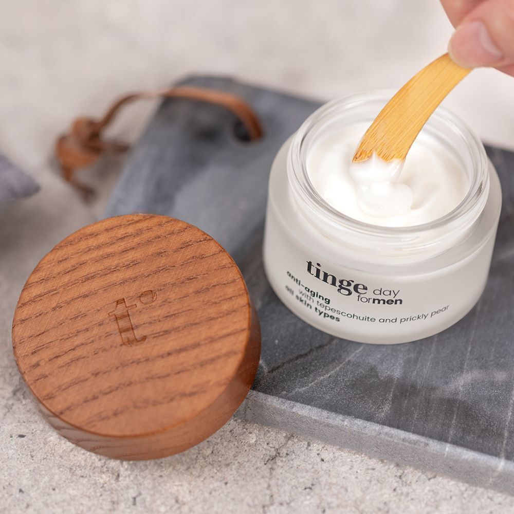 Geöffneter Tiegel mit Holzdeckel und Löffel. Aufschrift: Tinge day for men, anti-aging, mit Tepescohuite und Kaktusfeige, alle Hauttypen.