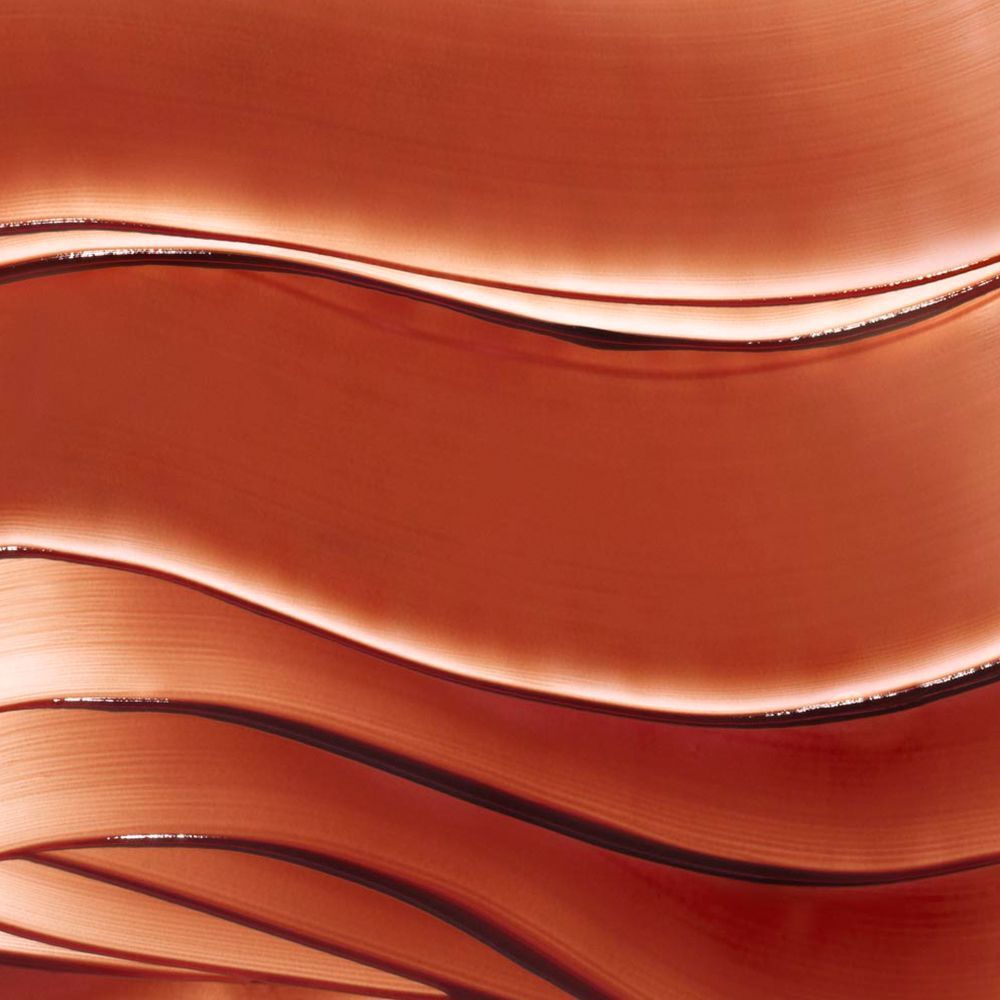 Nahaufnahme von wellenförmigen, bronzefarbenen Gel-Strichen. Textur mit Lichtreflexen.