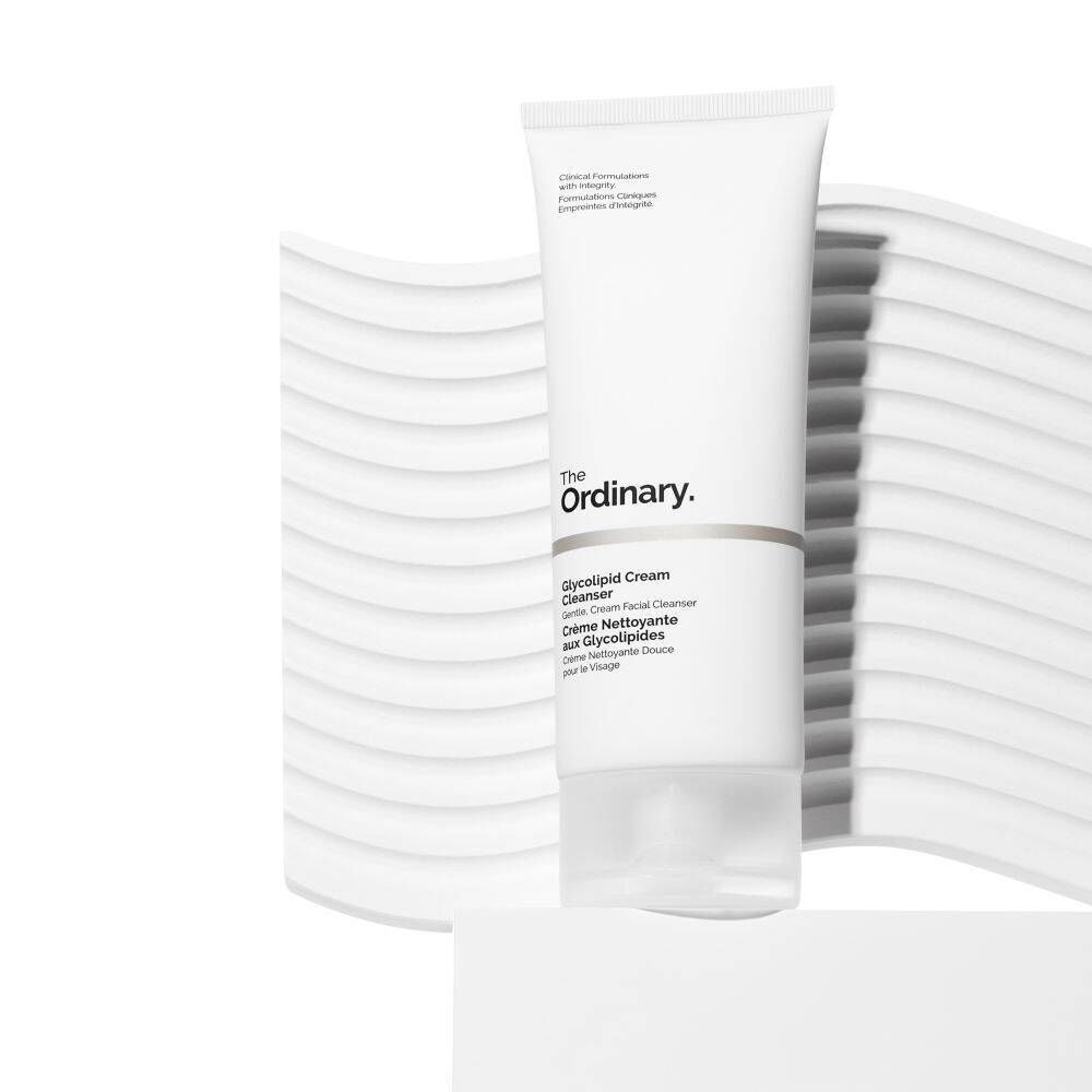 Eine Tube The Ordinary Glycolipid Cream Cleanser. Weiße Tube mit schwarzem Text, vor weißem Hintergrund.