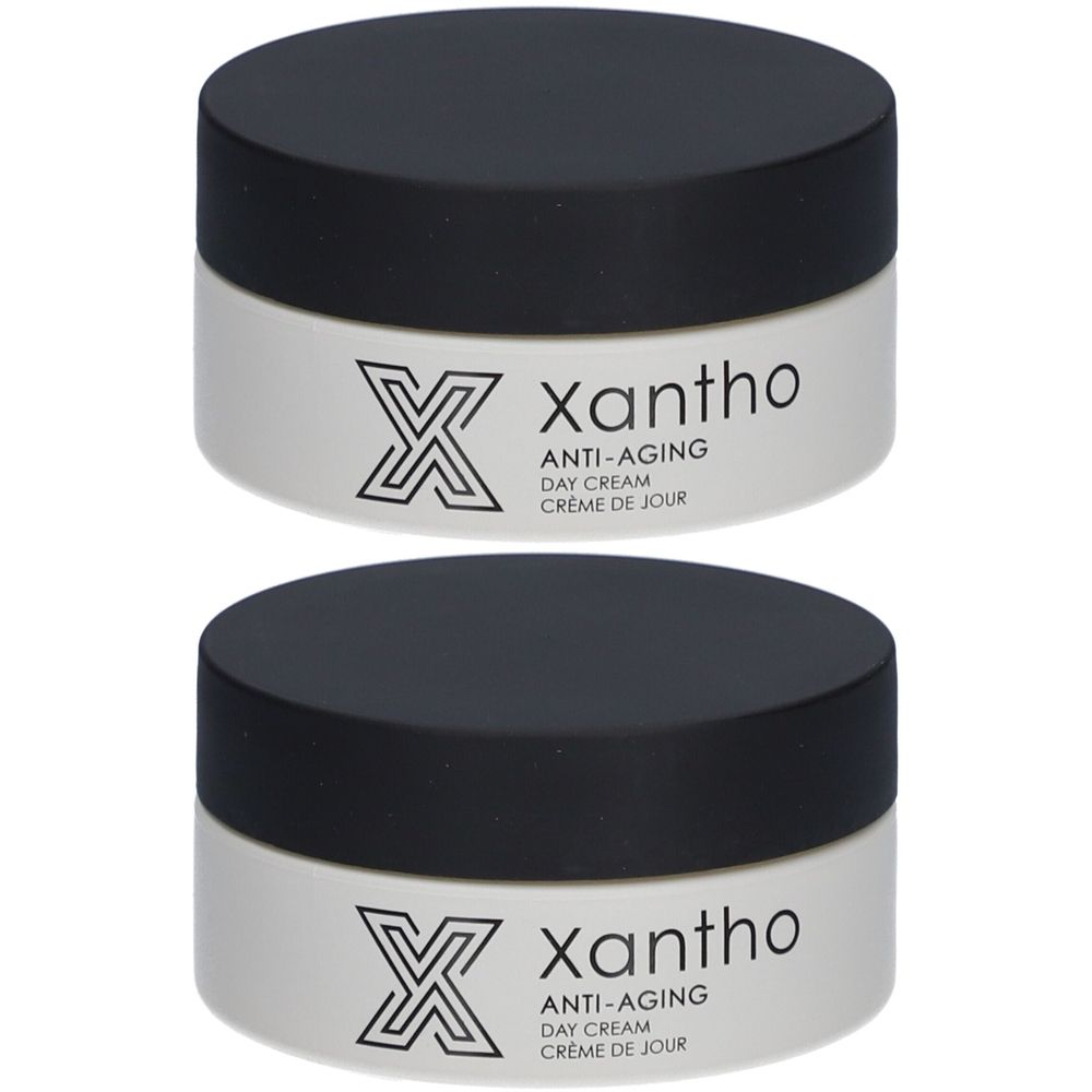 Deux pots de crème de jour anti-âge Xantho, couvercles noirs. Récipient blanc avec logo et texte.