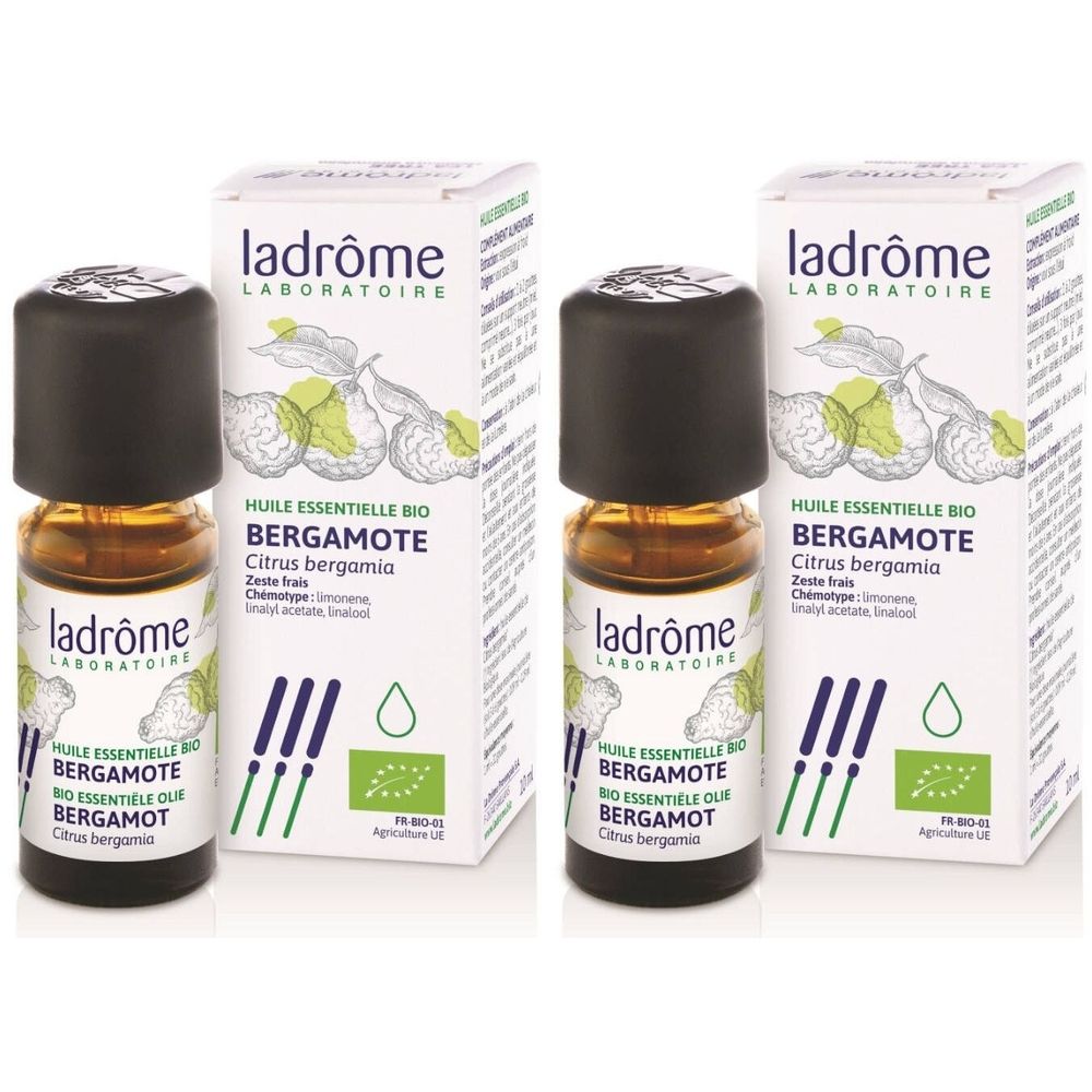Twee flesjes met zwarte dop en etiket, naast twee dozen met productinformatie en biologisch label.