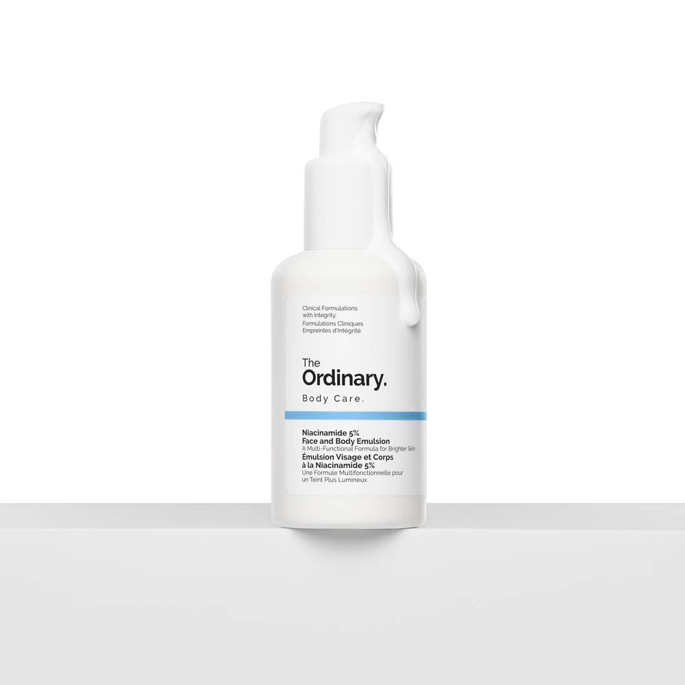 Weiße Flasche The Ordinary Body Care. Aufschrift: Niacinamide 5% Face and Body Emulsion. Produkt auf weißer Oberfläche.