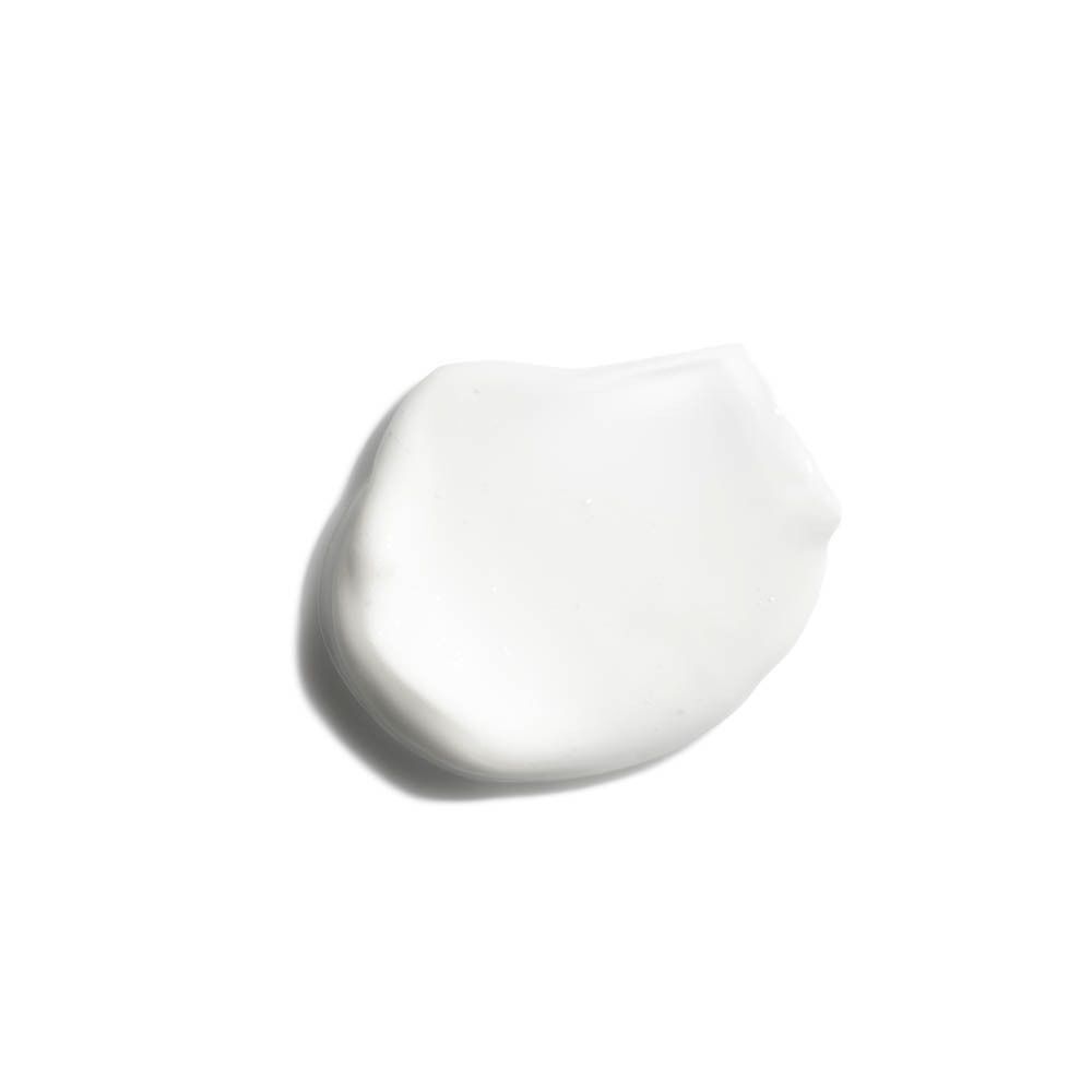 Ein Klecks weiße Lotion auf weißem Hintergrund. Keine Beschriftung sichtbar.