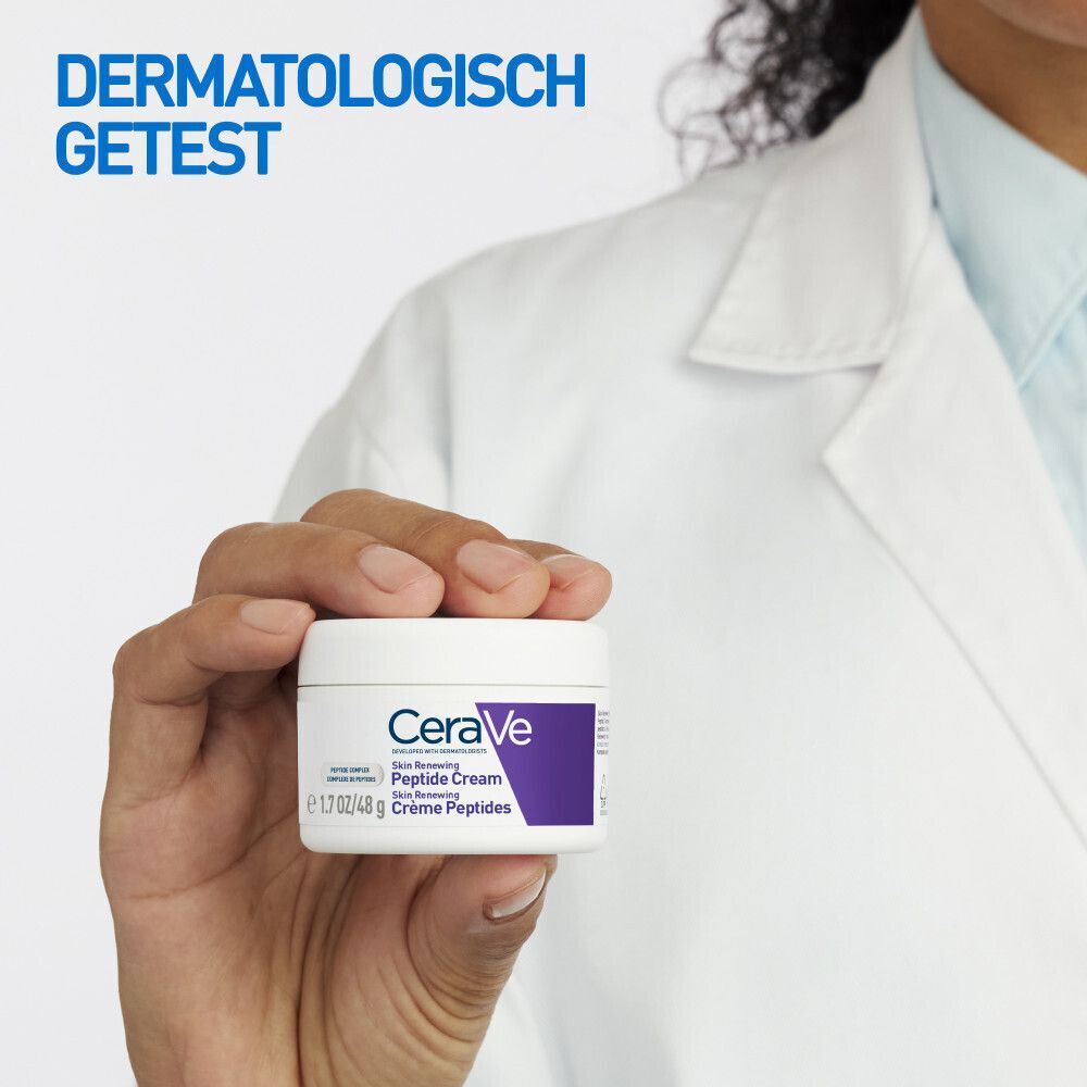 Hand houdt pot CeraVe Skin Renewing Crème Peptides. Wit, paars. Tekst.