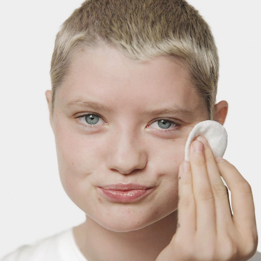 Eine Person verwendet Wattepad mit Clinique Clarifying Lotion.