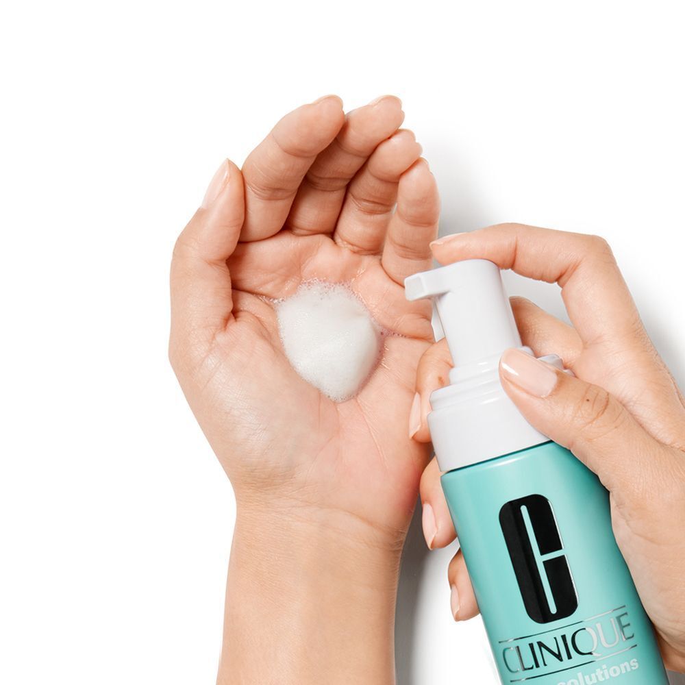 Schaum wird aus CLINIQUE Anti-Blemish Solutions™ Cleansing Foam in eine Hand gesprüht.