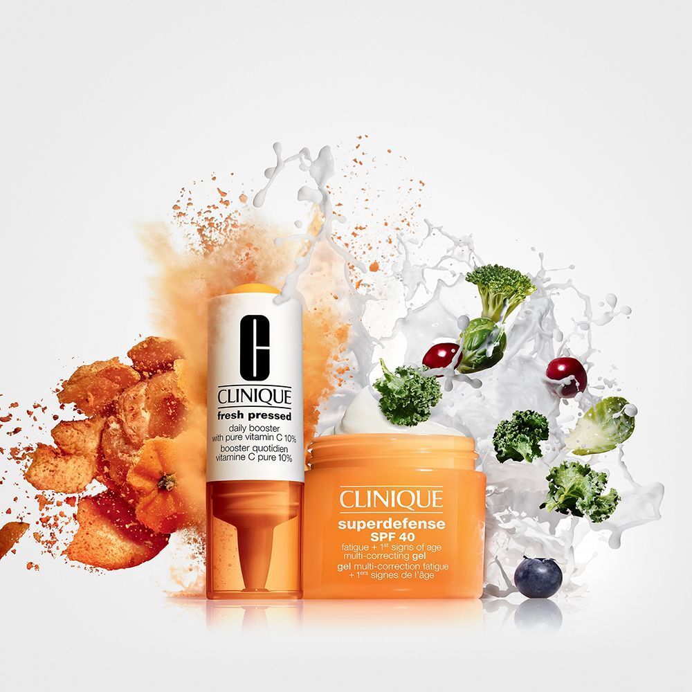 Clinique Vitamin C Booster und Superdefense Creme mit Zutaten und Spritzern.