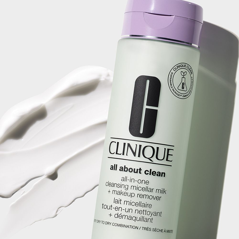 Eine Clinique All-in-One Reinigungs-Micellar-Milch Flasche mit lila Deckel, neben weißer Creme.