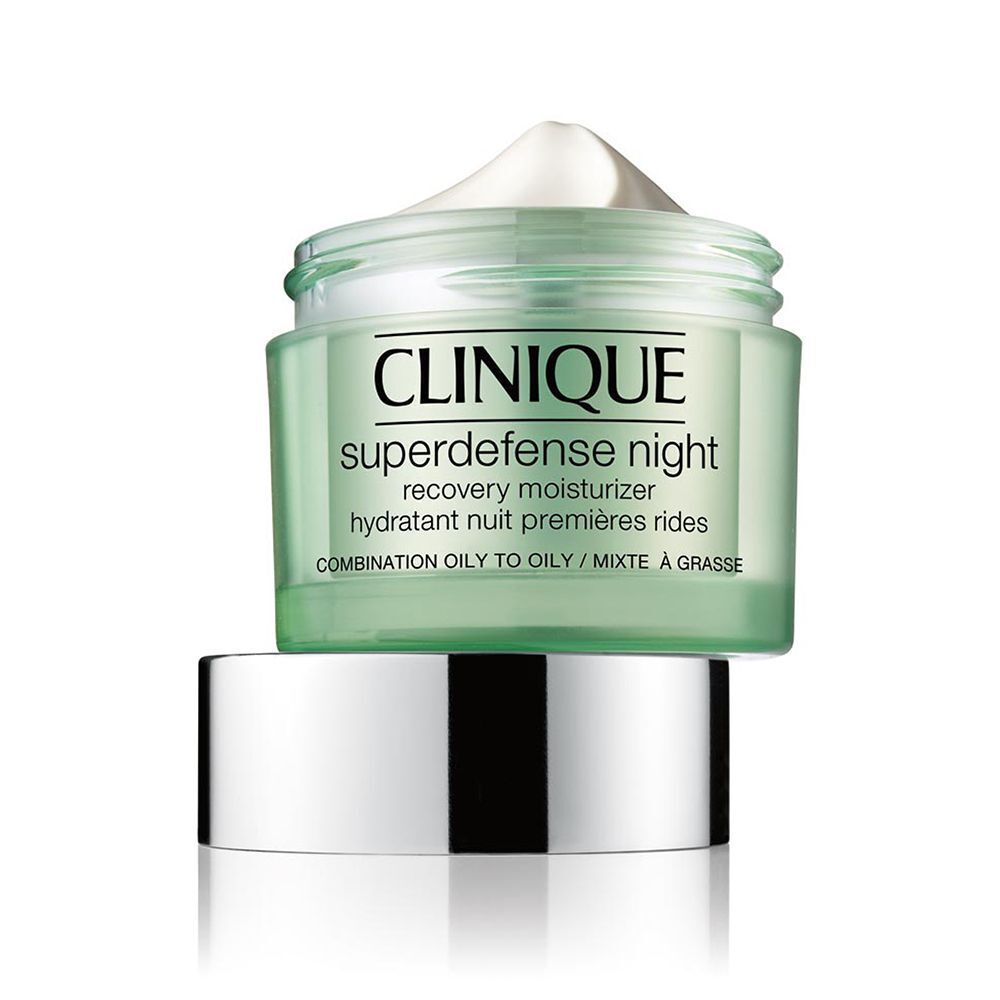 Ein offener Clinique Superdefense Nachtcreme Tiegel mit silbernem Deckel daneben.