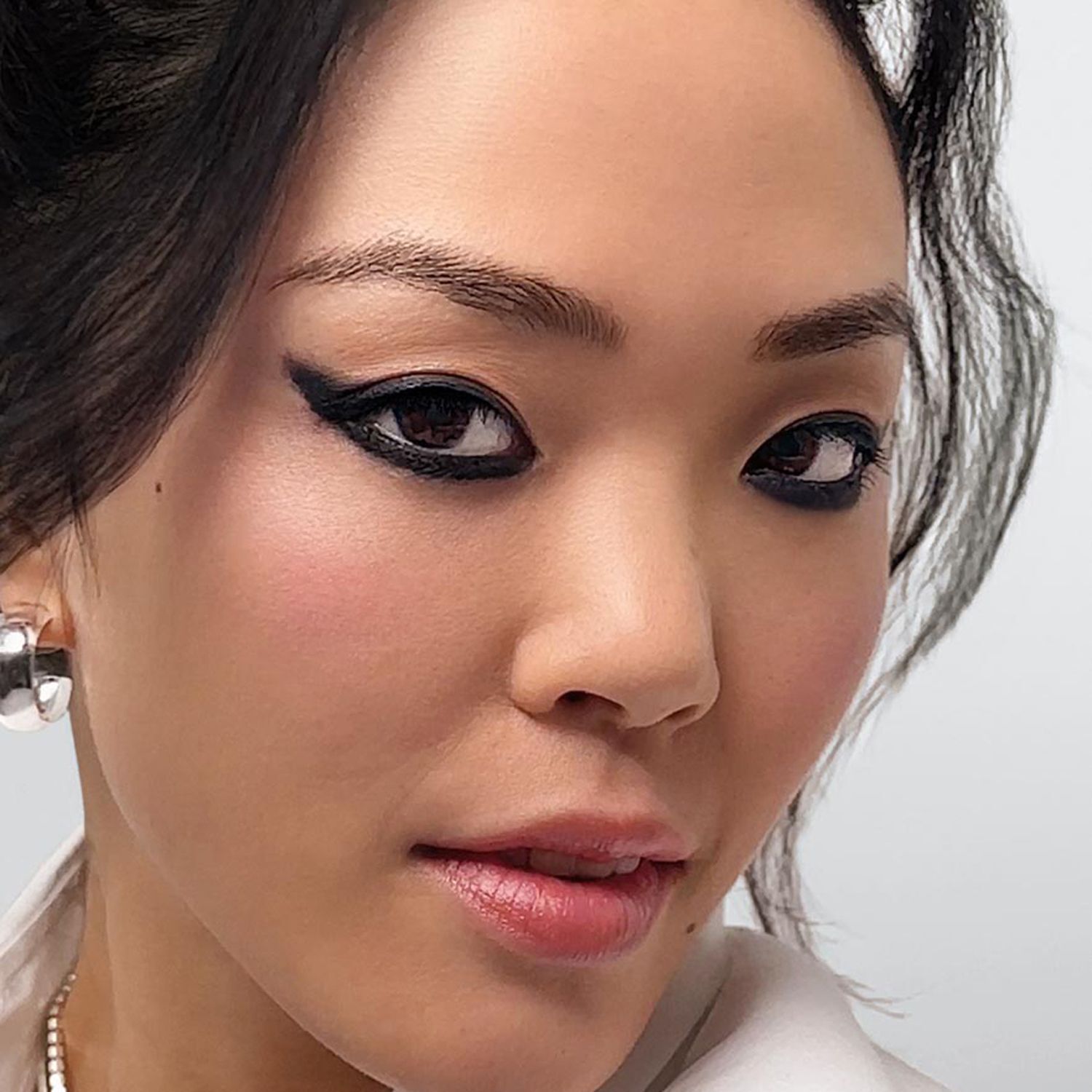 Nahaufnahme einer Frau mit dramatischem schwarzen Eyeliner-Make-up.