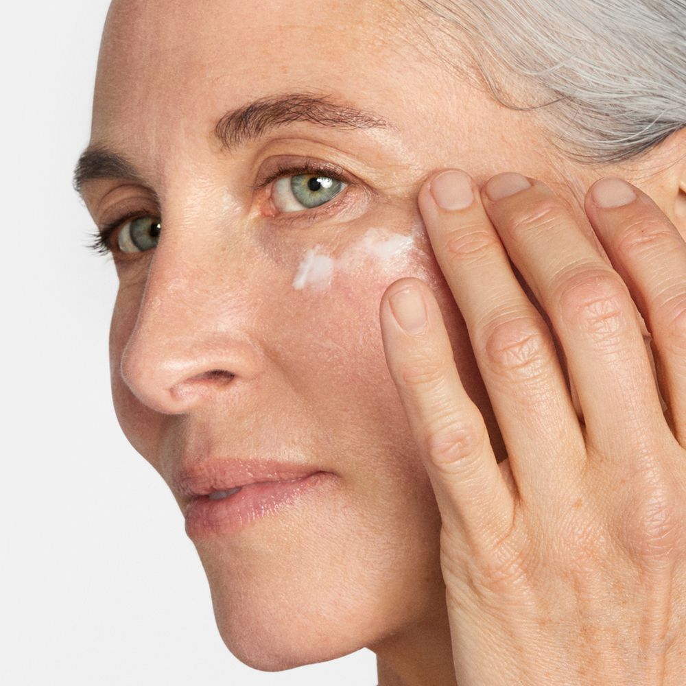 Eine Frau trägt Clinique Smart Clinical Repair Augencreme auf.