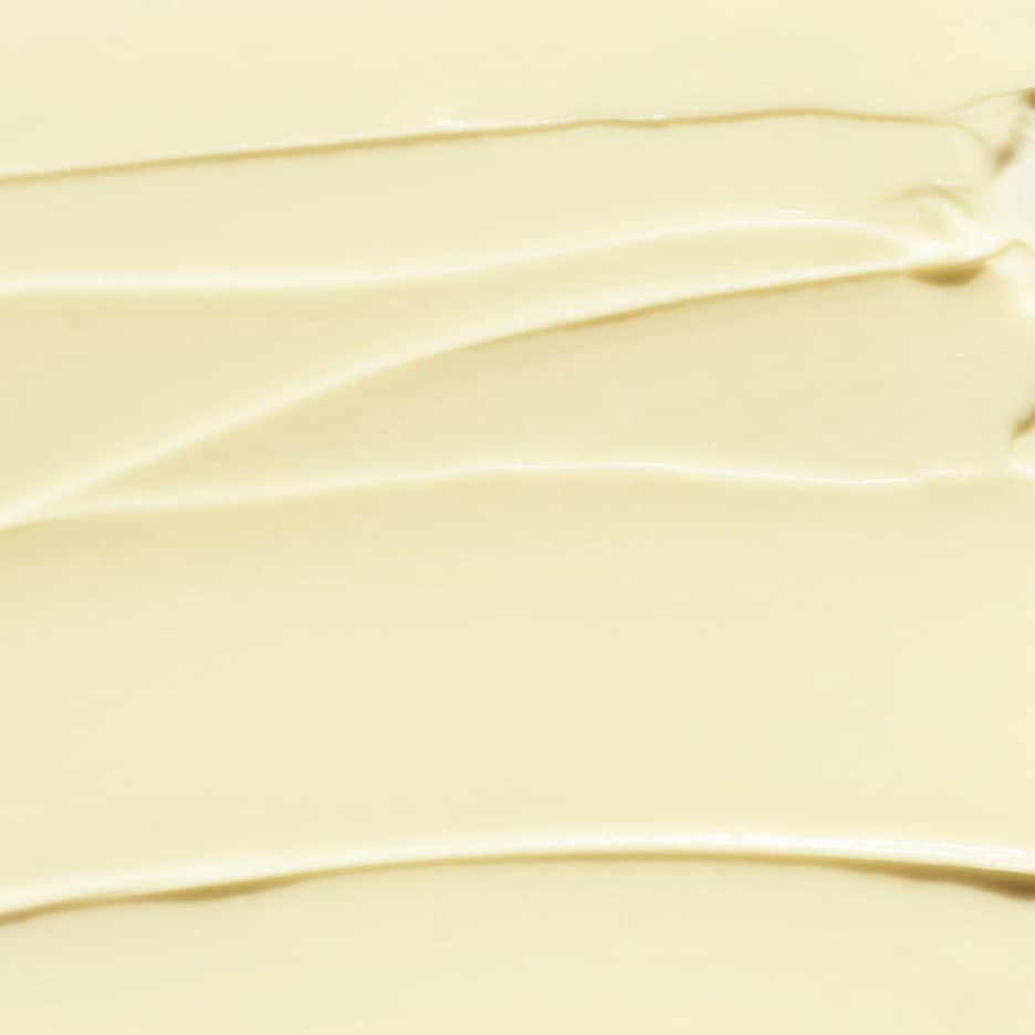 Nahaufnahme der cremigen Textur von CLINIQUE Deep Comfort Hand- und Nagelcreme. Glatte, wellenförmige Anwendung.