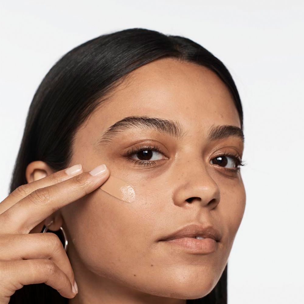 Eine Frau trägt CLINIQUE Anti-Blemish Solutions Liquid Makeup auf.