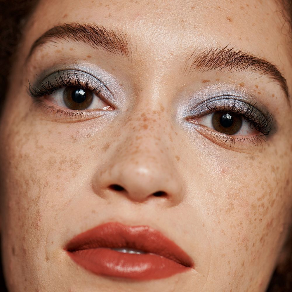 Nahaufnahme eines Gesichts mit geschminkten Augen und Lippen. CLINIQUE Quickliner™ für Brows nicht sichtbar.