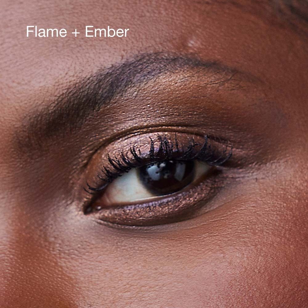 Nahaufnahme eines Auges mit schimmerndem Lidschatten in Flamme und Glut.