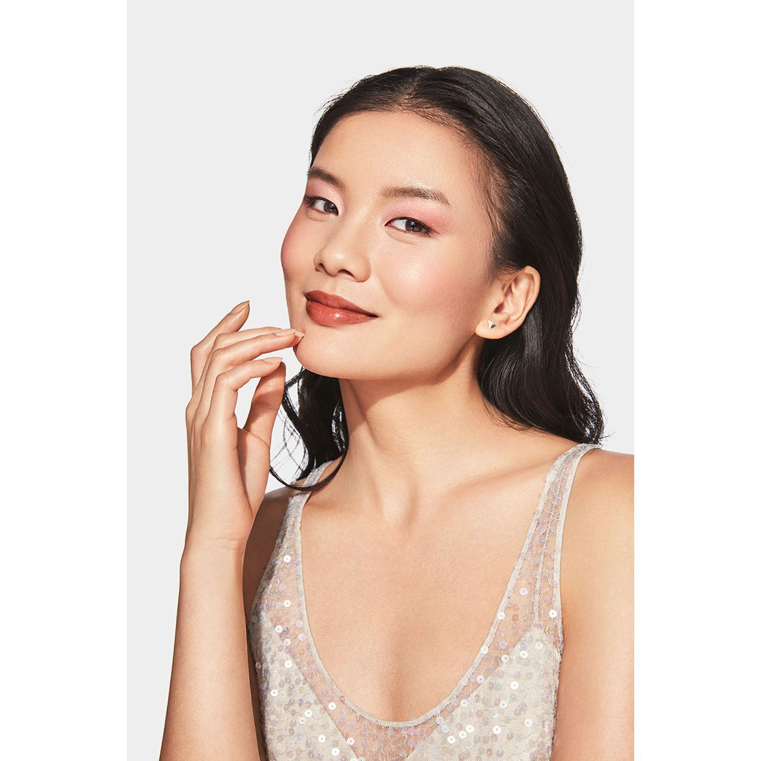 Frau mit aufgetragenem Clinique Blushing Blush Puder-Rouge in Smoldering Plum auf den Wangen.