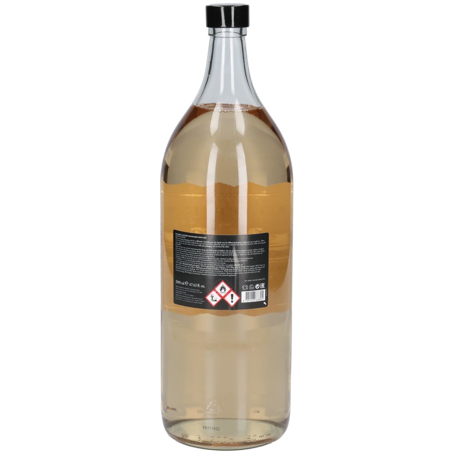 Transparente Glasflasche mit schwarzem Deckel. Rückseitiges Etikett mit Produktinformationen und Gefahrensymbolen.