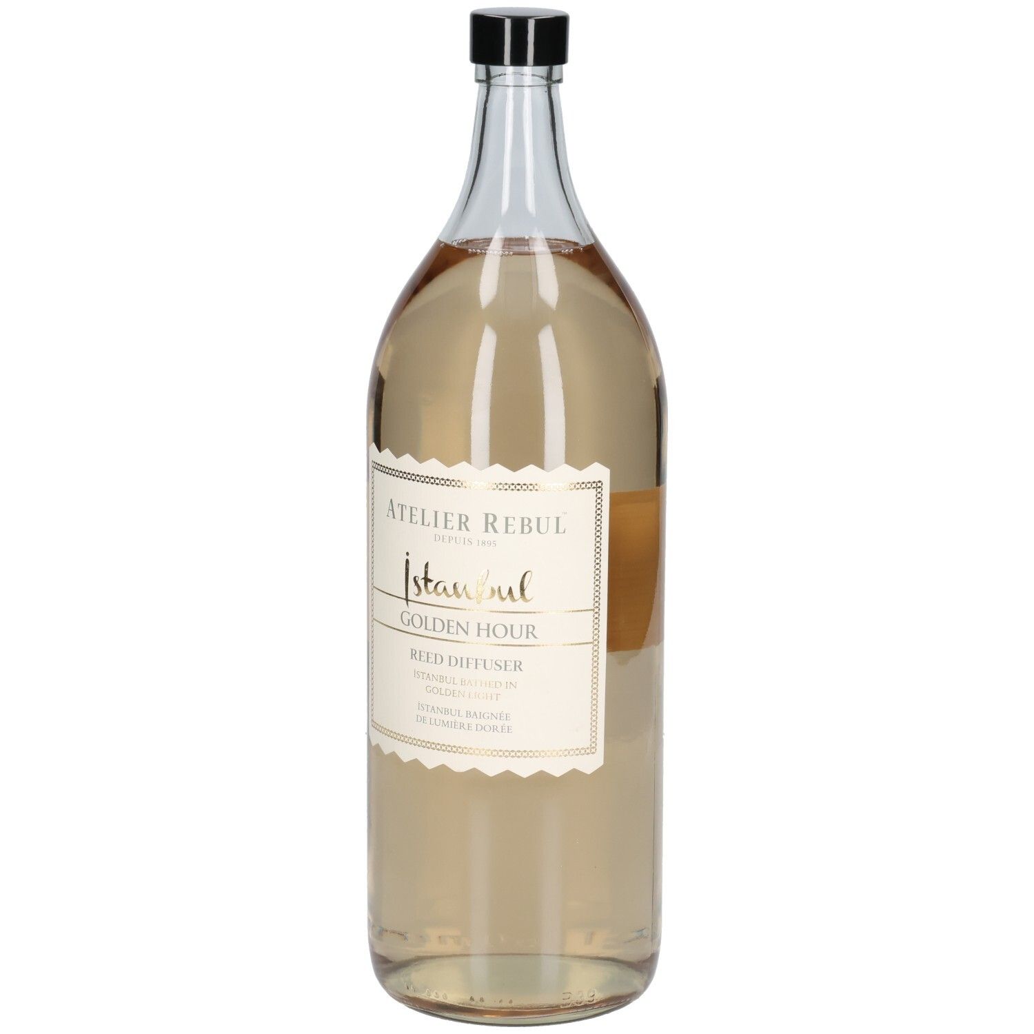 Große, transparente Glasflasche mit schwarzem Deckel. Etikett mit goldfarbenem Schriftzug: Atelier Rebul Istanbul Golden Hour Reed Diffuser.