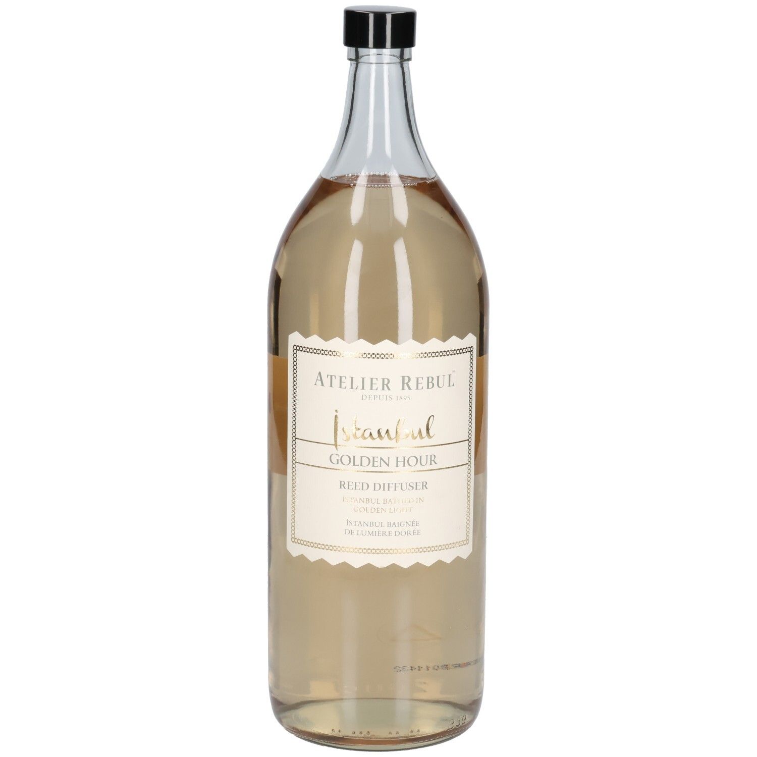 Große, transparente Glasflasche mit schwarzem Deckel. Etikett mit goldfarbenem Schriftzug: Atelier Rebul Istanbul Golden Hour Reed Diffuser.