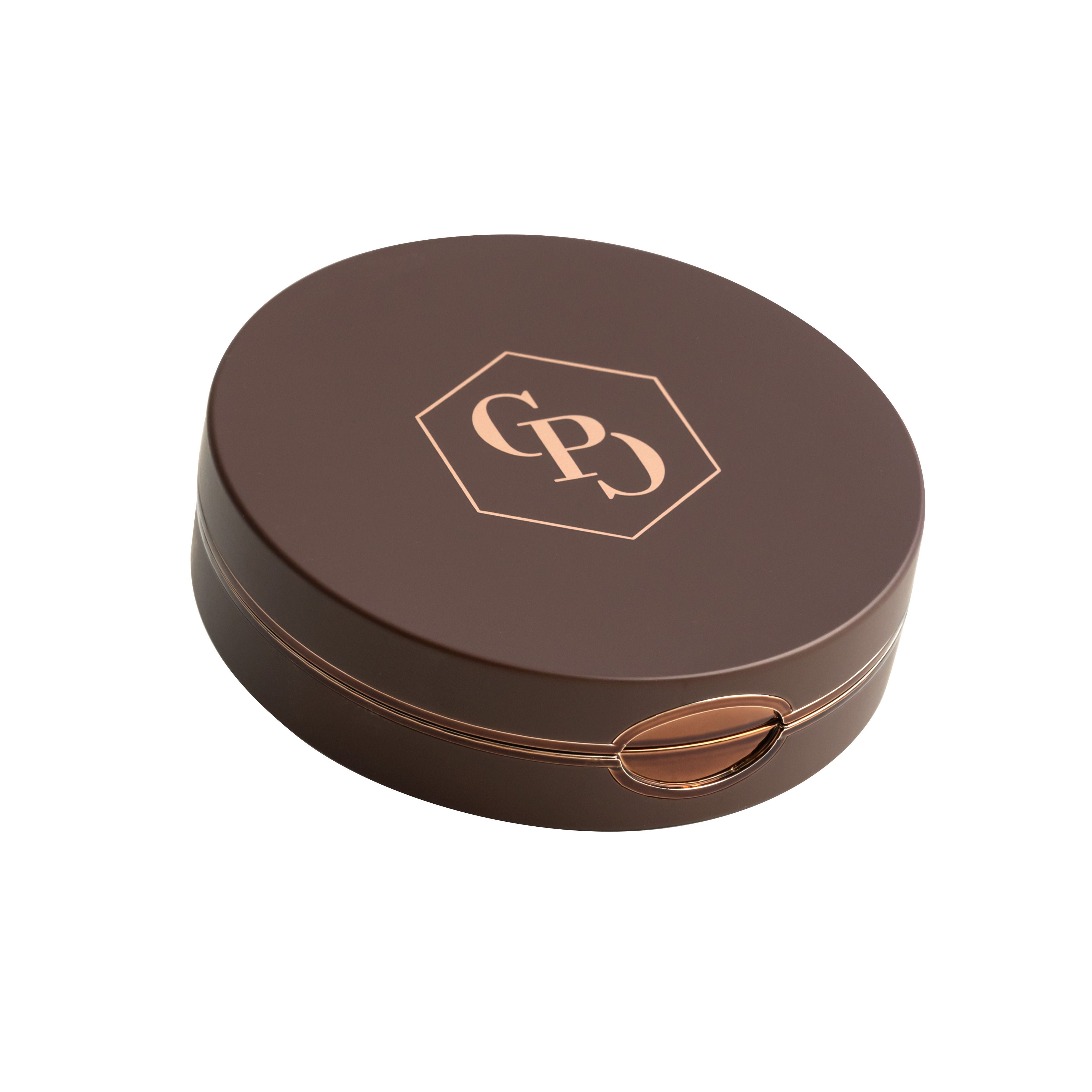 Boîtier de poudre bronzante compacte ronde fermée. Couleur marron, logo doré. Bord doré.