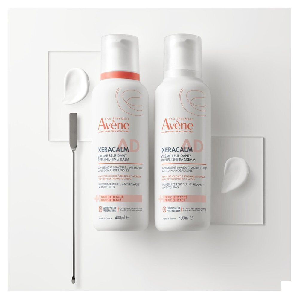 Deux flacons Avène XeraCalm A.D. et une spatule. Texte: XeraCalm A.D., Crème relipidante, 400ml.