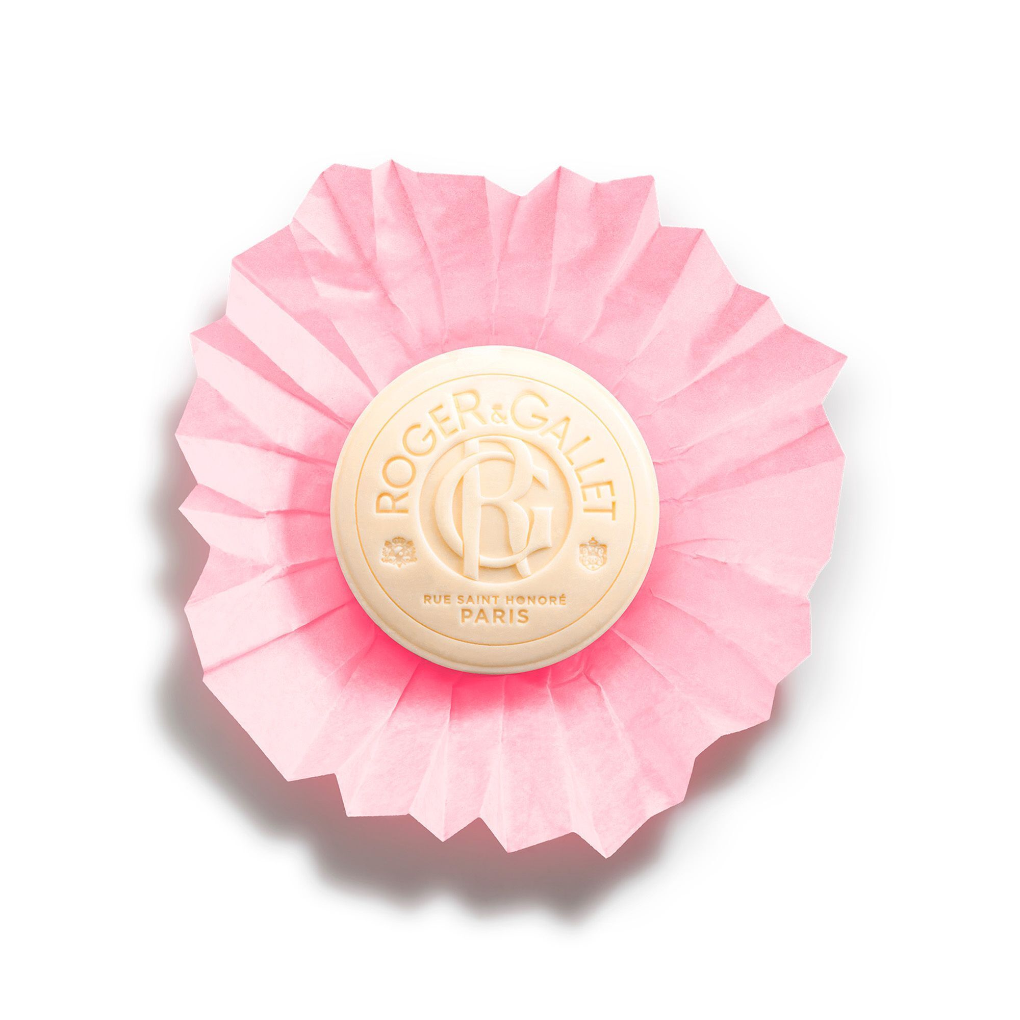 Savon rond crème sur papier plié rose. Inscription: Roger & Gallet. Logo et texte.