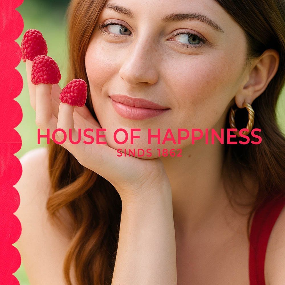 Vrouw met frambozen op haar vingers. Tekst: HOUSE OF HAPPINESS Sinds 1862.