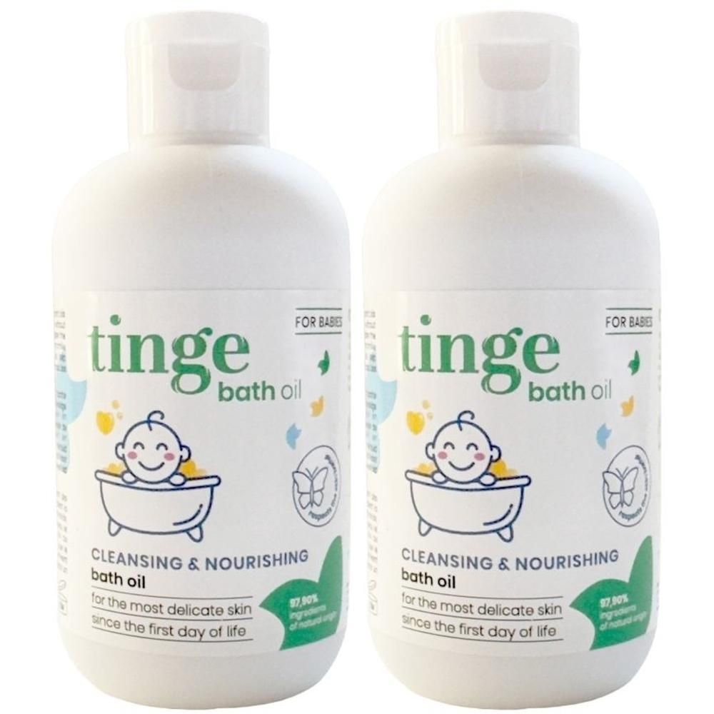 Twee witte flessen Tinge babybadolie met klapdeksel. Etiket toont baby in bad.