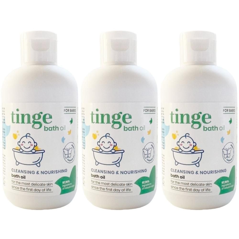 Trois bouteilles blanches d'huile de bain Tinge pour bébé avec bouchons à rabat. L'étiquette présente un dessin animé de bébé souriant dans une baignoire.