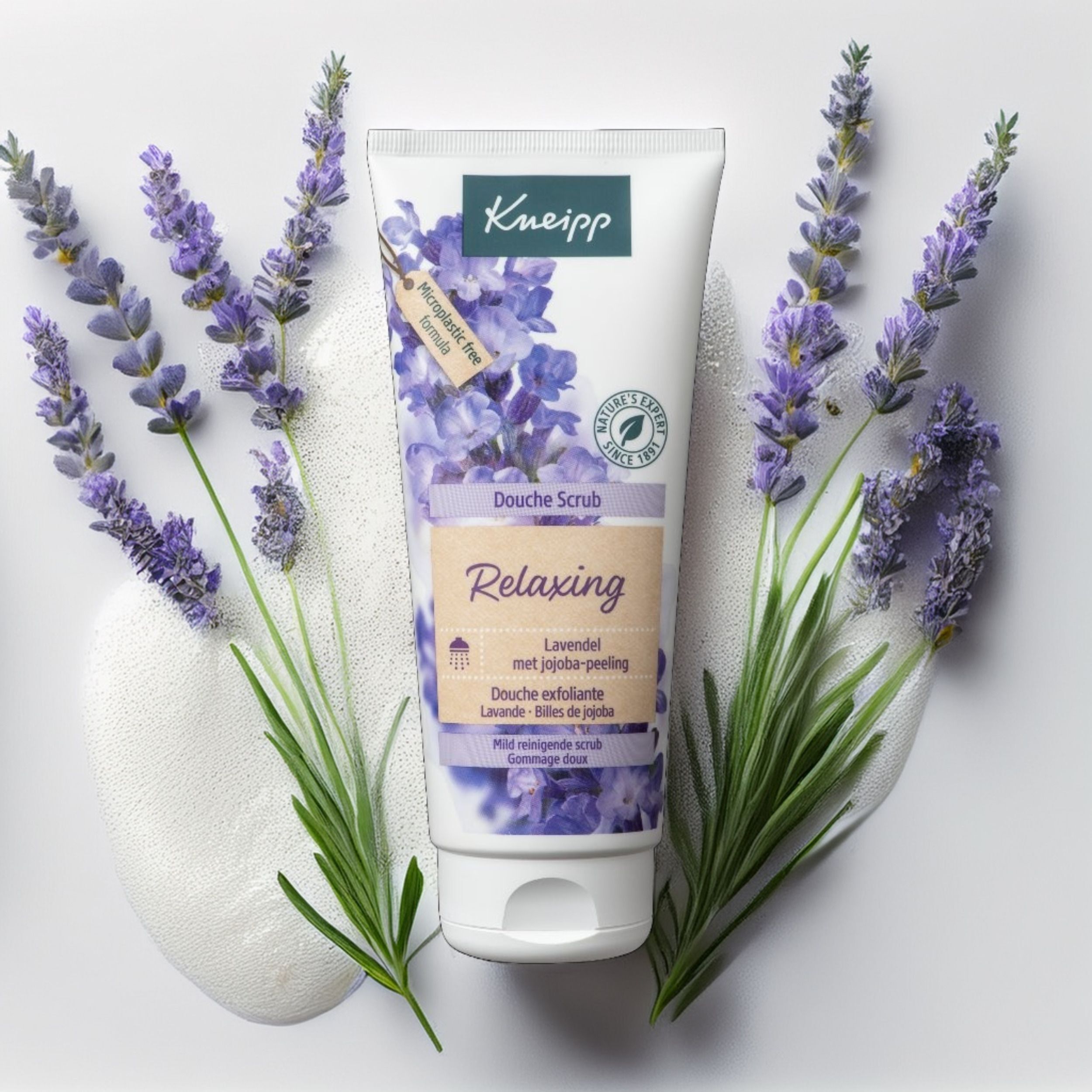 Gommage Douche Relaxant Lavande Billes de Jojoba Kneipp, entouré de lavande.