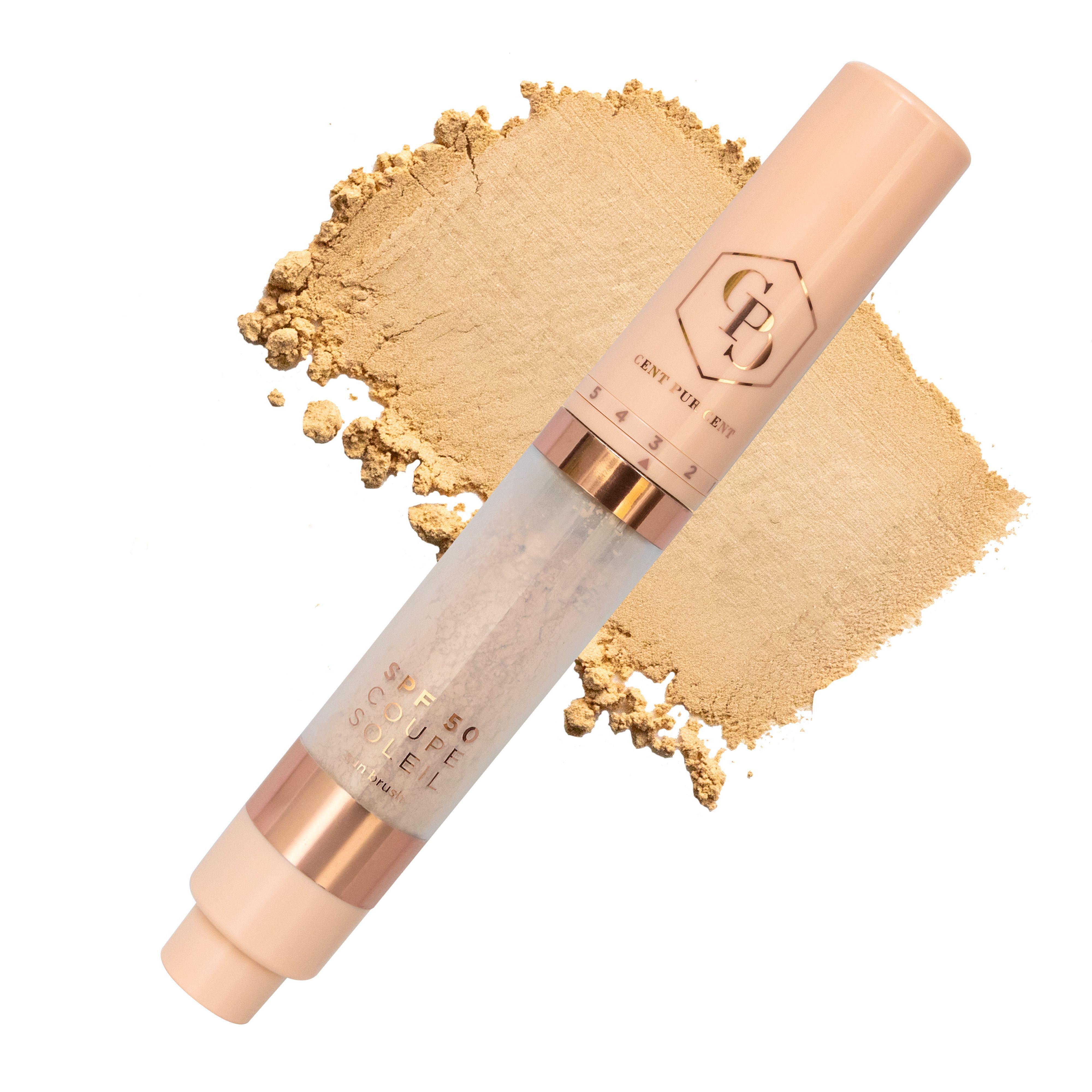 Un applicateur Cent Pur Cent Coupe Soleil SPF50 Sunbrush avec embout brosse, à côté d'une traînée de poudre dorée.