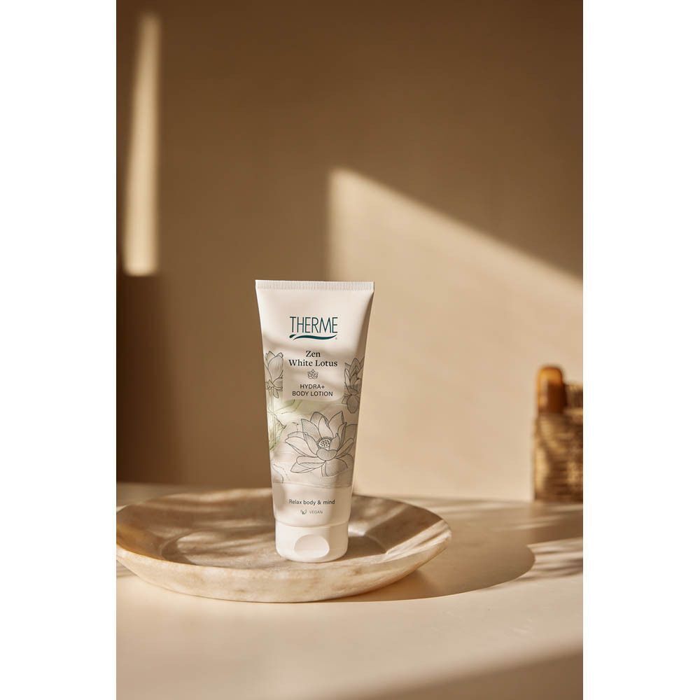 Un tube de Lotion Corporelle Therme Zen White Lotus sur une coupelle.