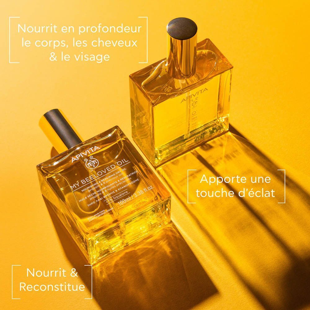 Deux flacons Apivita My Beeloved Oil sur fond jaune, nourrissant corps, cheveux et visage.