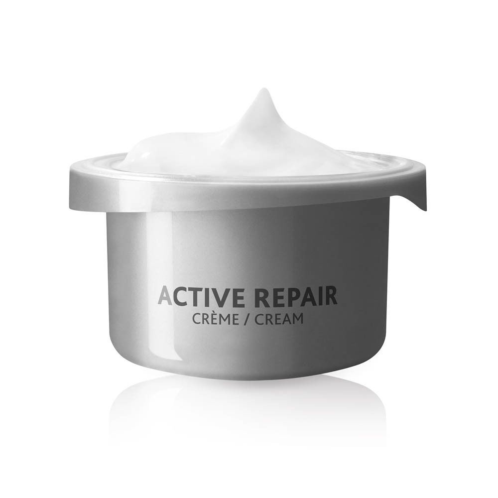Een potje met opschrift "ACTIVE REPAIR CRÈME / CREAM", gevuld met witte crème.