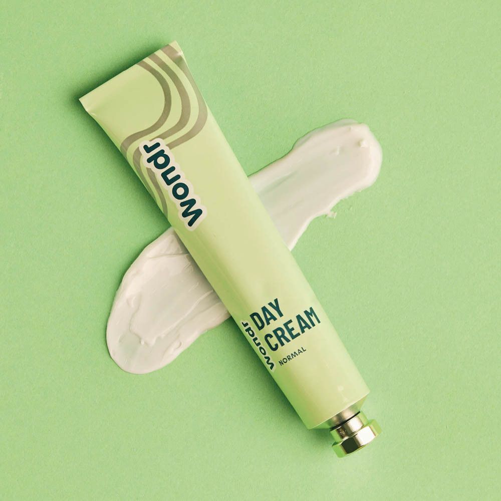 Tube WONDR Day Cream avec un échantillon de crème sur fond clair.