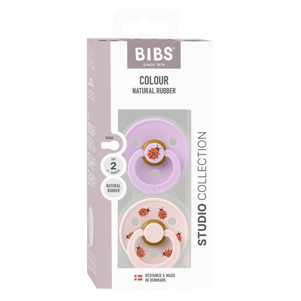 Twee BIBS fopspenen met gele natuurrubberen speen en roze schild met lieveheersbeestjes.