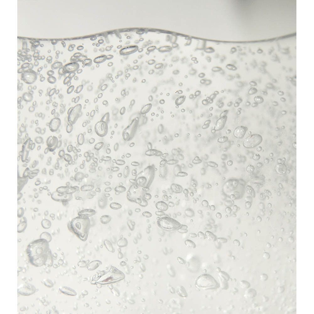 Gros plan sur le liquide clair avec de nombreuses bulles d'air dans un récipient.