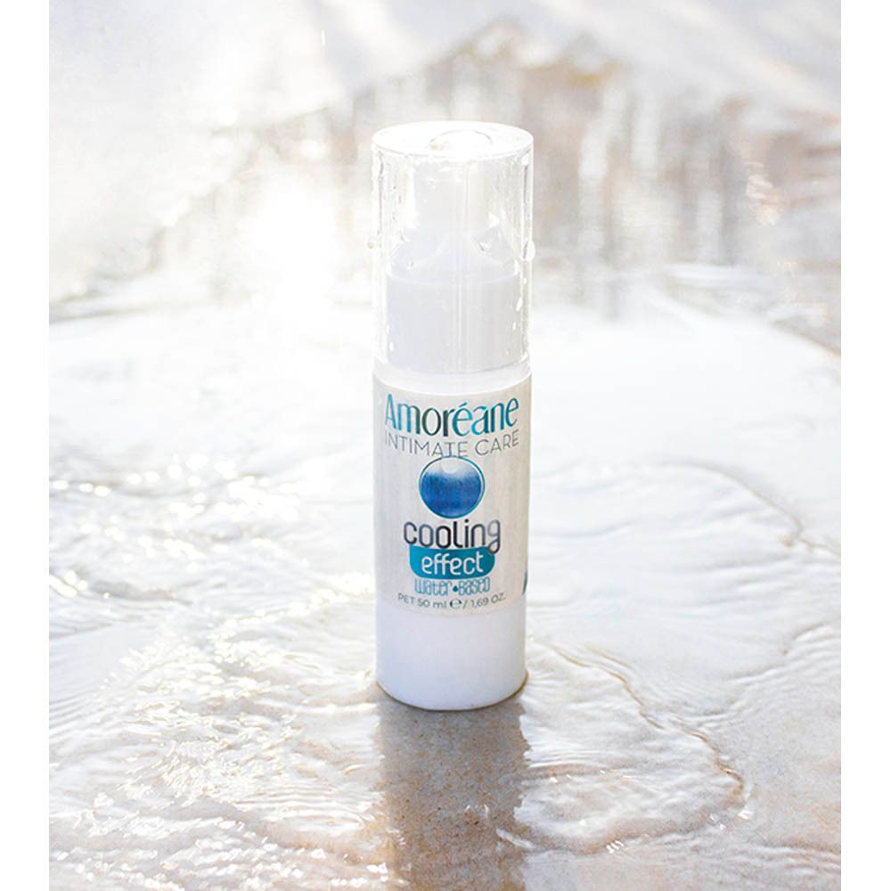 Een flacon AMOREANE Intimate Care Cooling Effect met pompdose op nat zand.