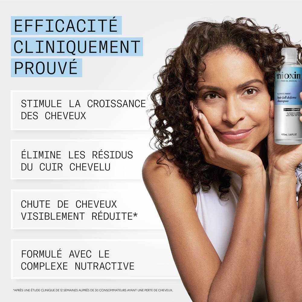 Femme tenant une bouteille de shampooing Nioxin.