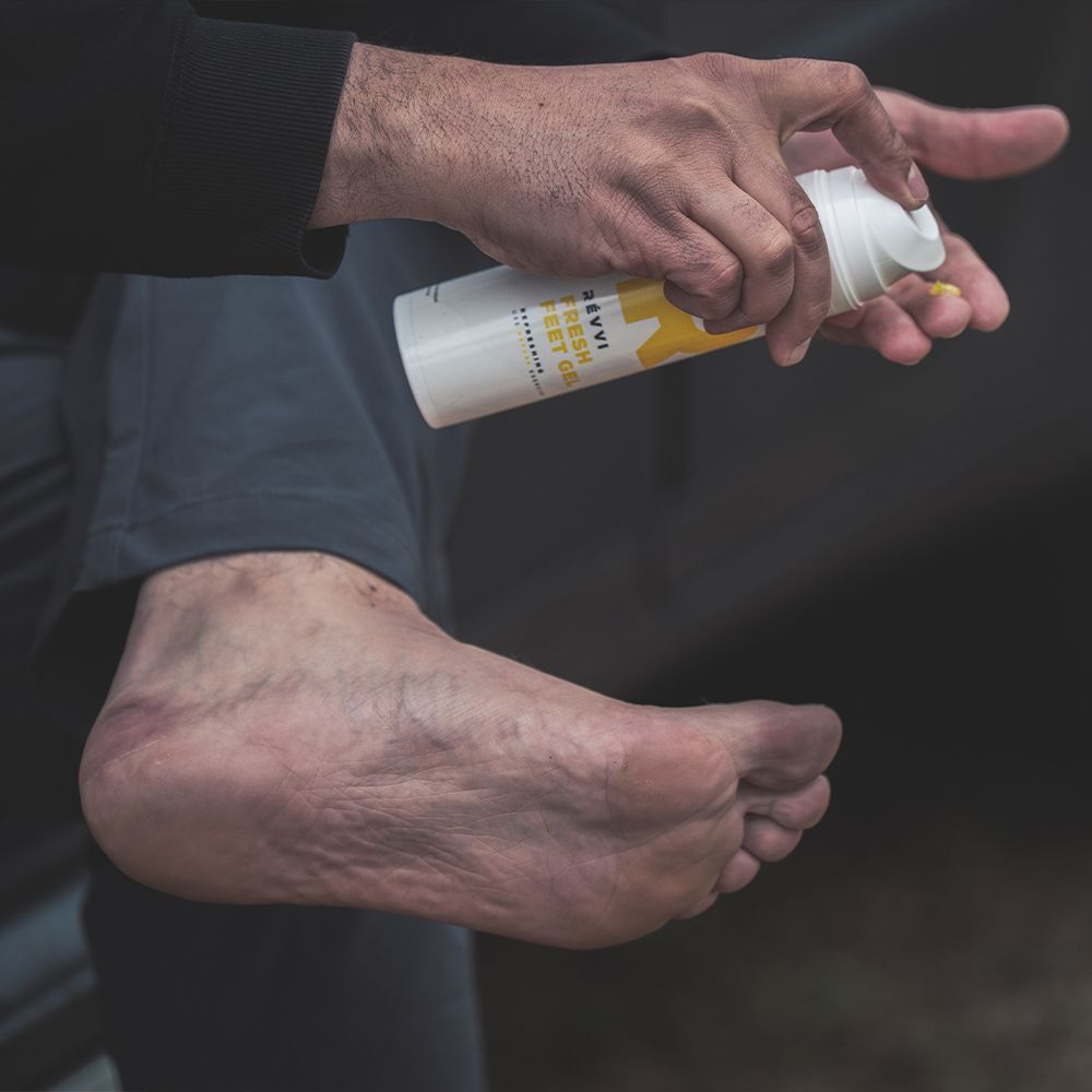 Handen drukken gele gel uit een witte doseerfles in een handpalm.