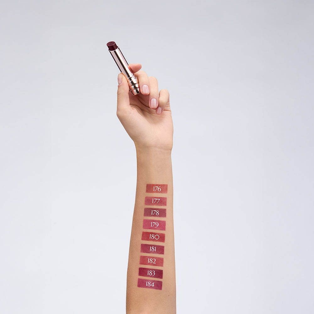 Arm met aangebrachte lippenstiftkleuren 176-184. Een hand houdt de lippenstift vast.