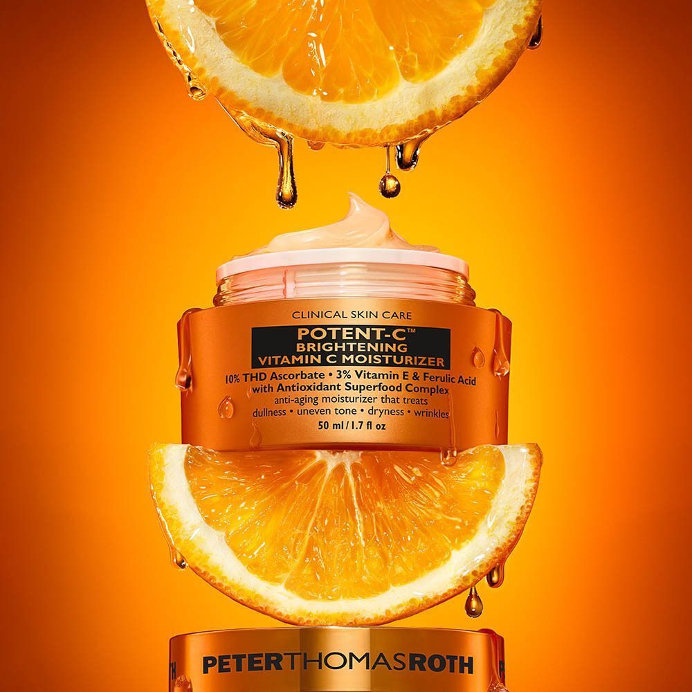 Een pot Peter Thomas Roth Potent C Brightening Vitamin C Moisturizer tussen twee sinaasappelschijfjes.