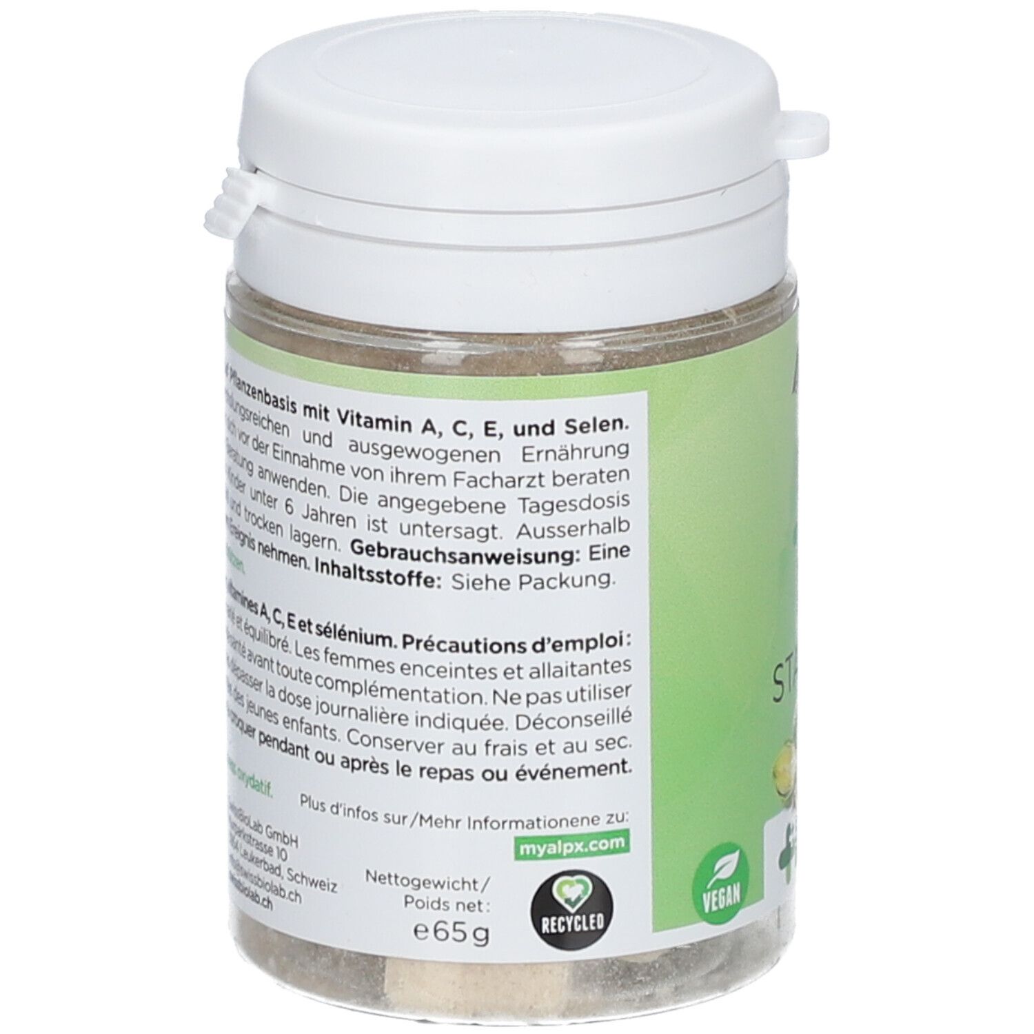 Boîte avec couvercle blanc. Inscription : Alpx, F, STAY FIT. Swiss Made. Texte en allemand et français. Vegan.