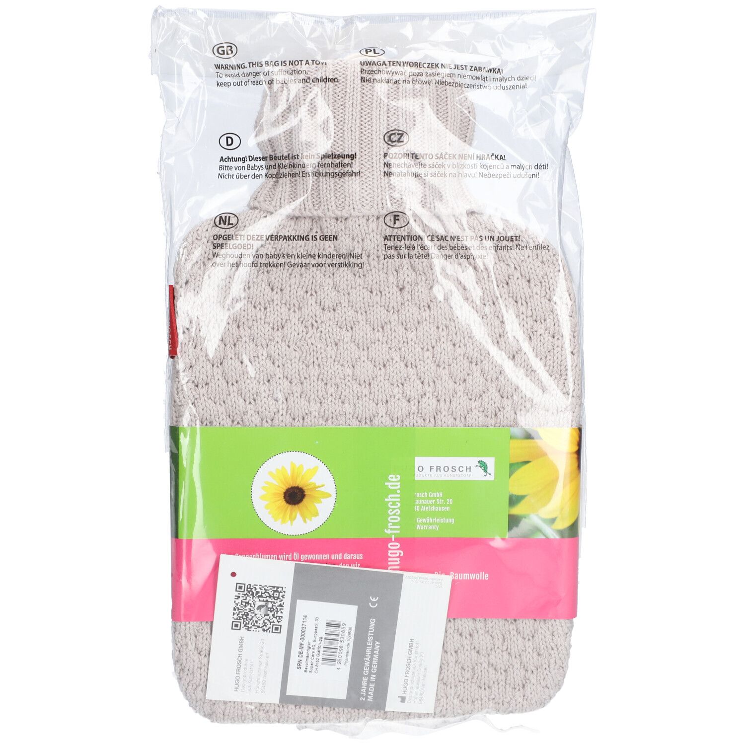Bouillotte dans un emballage transparent. Housse en tricot beige, bande verte avec logo et tournesol. Étiquette avec code QR.